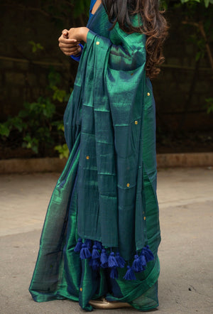 Model draped in peacock green tissue silk saree, side pose