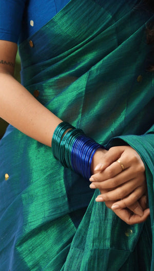 Full-length peacock tissue saree with royal blue blouse, front view