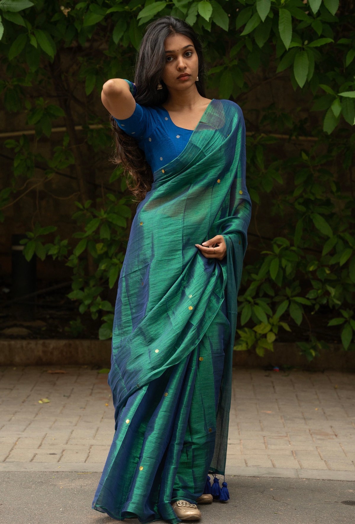 Royal blue raw silk blouse paired with peacock tissue silk saree