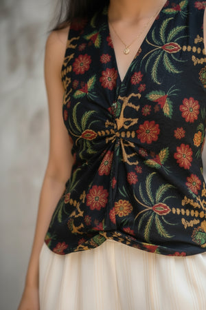 Close-up of the black floral crop top showcasing colorful floral prints, a stylish twist-front detail, and premium cotton fabric.