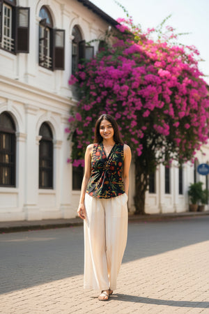 Black floral crop top for women paired with cream trousers, featuring a sleeveless design and elegant floral print for everyday wear.