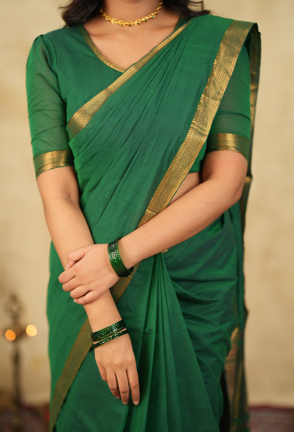 Handloom green cotton blouse paired with traditional saree and wide neckline ethnic styling