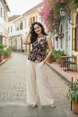 Krithi Moonflower floral twist front crop top for women paired with wide-leg trousers, featuring a sleeveless V-neck design.
