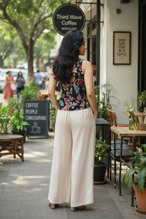 Women’s floral sleeveless crop top with twist front styling, paired with relaxed-fit trousers for a chic casual look.